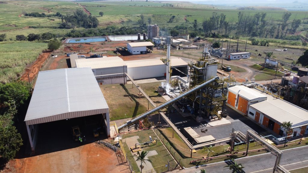 Instalação industrial moderna com tecnologia de biomassa, simbolizando a transição energética e a busca por autonomia sustentável.
